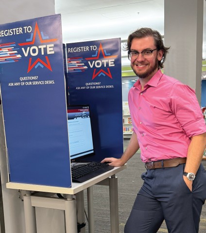 Man standing at voter registration kiosk